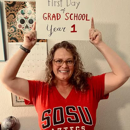 First year graduate school sign above SDSU Students head