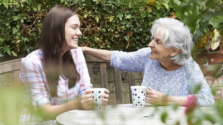 Grandmother and grandaughter drinking coffee together