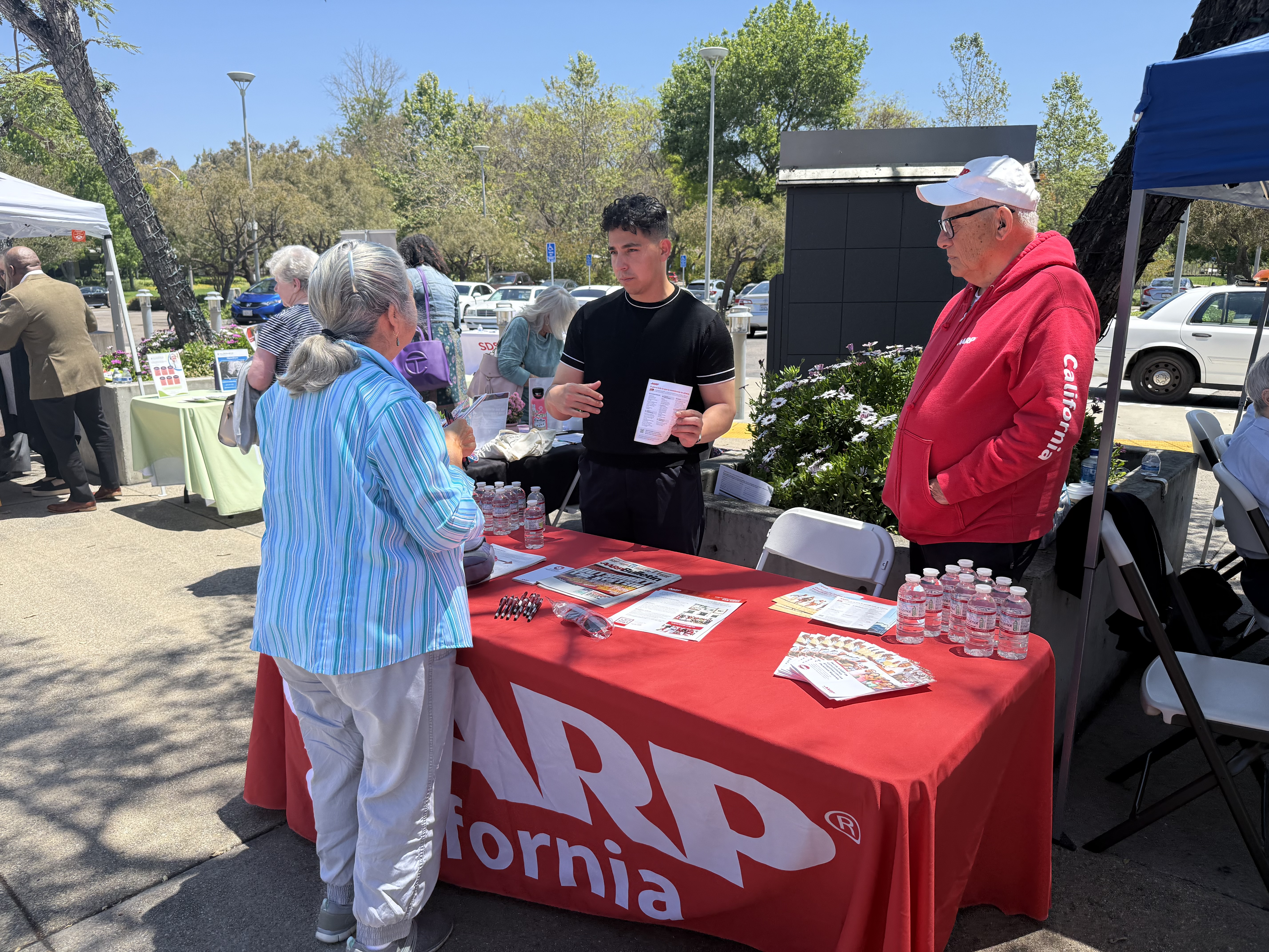 AARP Booth with people conversing around it.