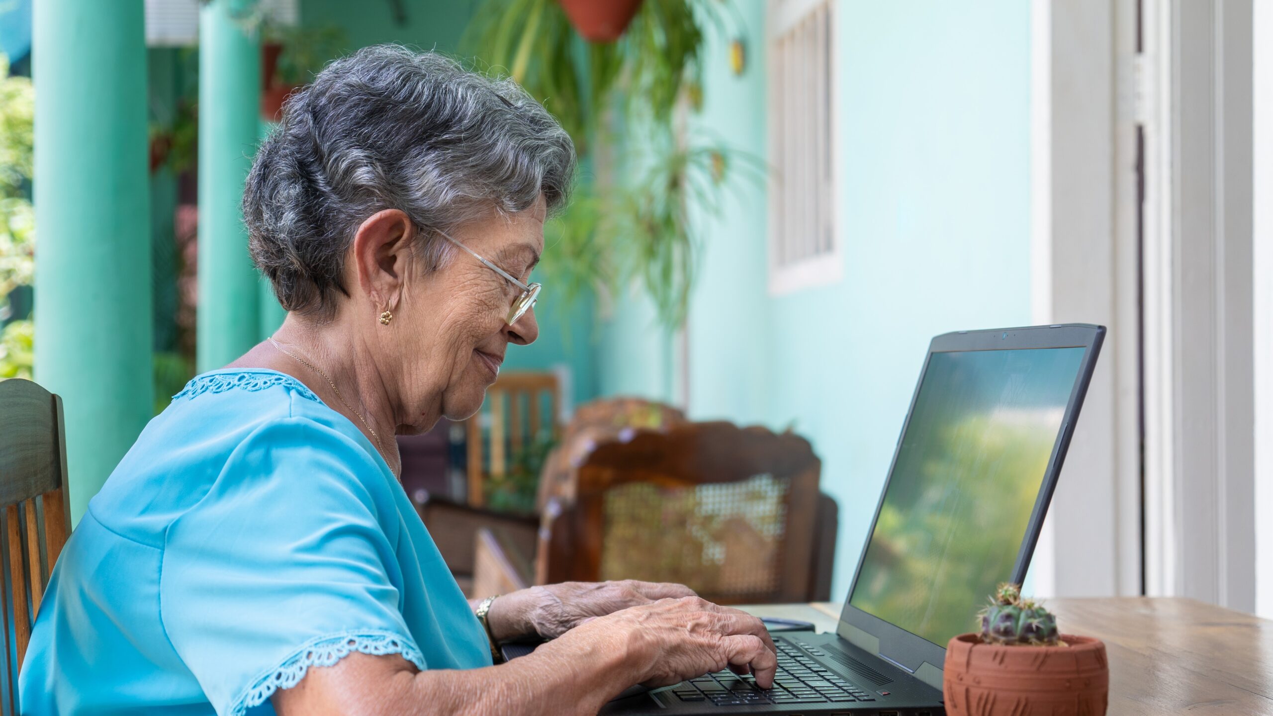 Smiling Elderly Woman Wearing Glasses With a Laptop