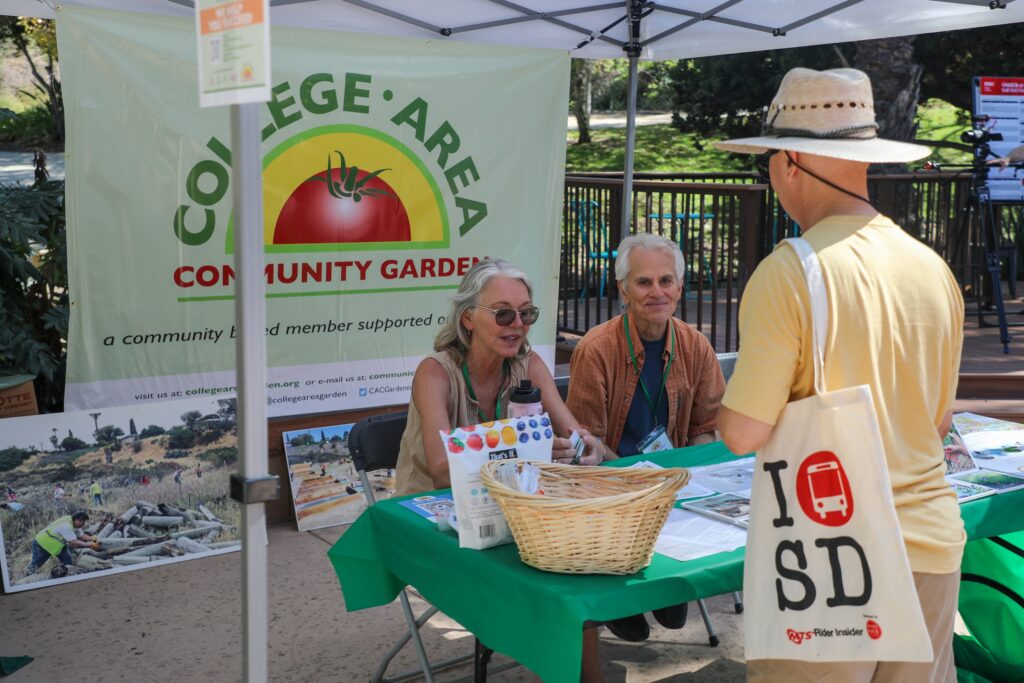 College Area Community Garden Volunteers talking to a patron.