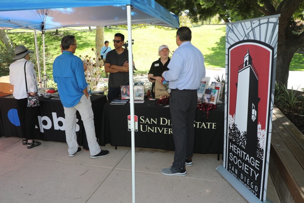 Multiple people having a conversation at the KPBS and SDSU booths