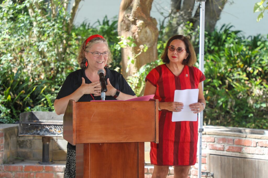 OSHER Event organizer giving a speech with SDSU President Adela de la Torre standing next to her