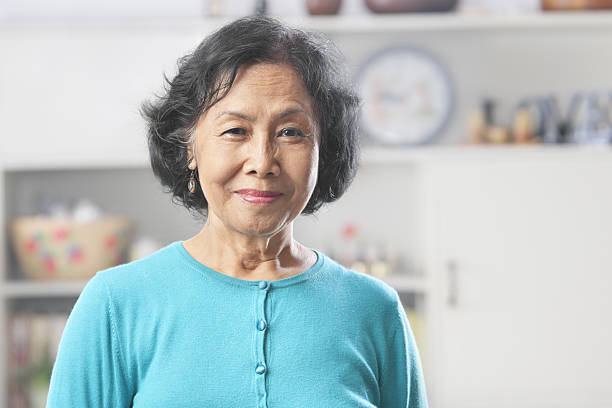 Senior Asian woman at home gazing to camera