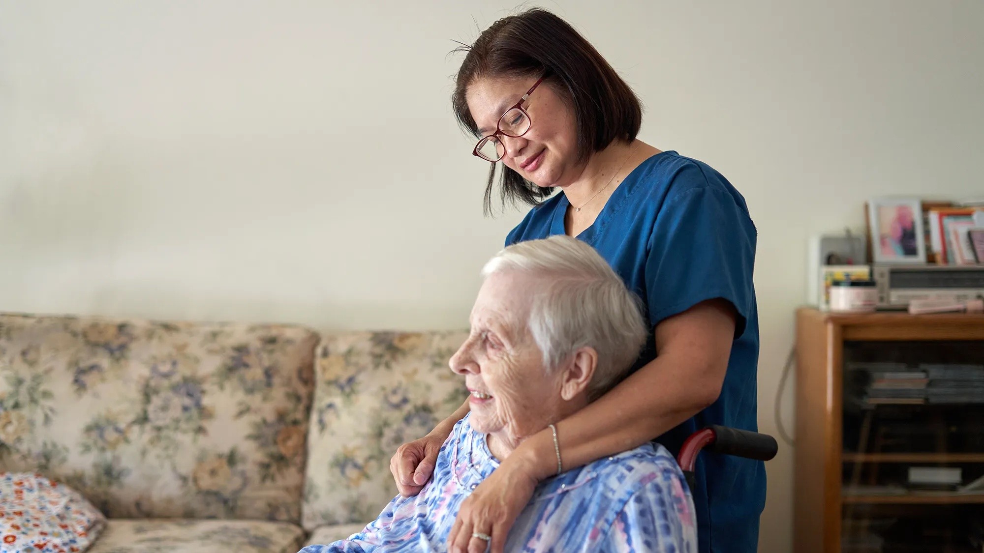 Female care taker, holding onto an elderly person.